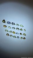 Group shot of approximately 24 faceted multicolored tanzanite stones