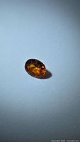 Front view of oval faceted orange gemstone