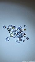 Group of loose multicolor faceted tanzanite stones on white background