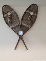 Full view of both wooden snowshoes crossed on wall