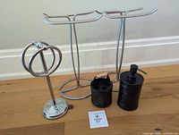 Group shot of soap dispenser, toothbrush holder, ring towel holder, and two freestanding towel stands