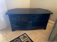 Front view of black corner TV stand closed