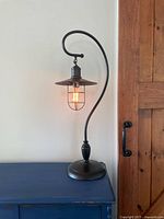 Full view of black metal table lamp lit