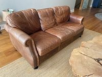 Front view of brown leather three-seat sofa