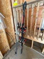 Full view of skis and poles leaning against wall