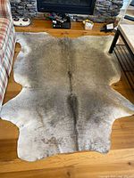 Full view of grey cowhide rug on floor