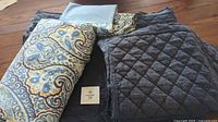 Paisley duvet cover, light blue pillow case, folded quilt, label visible