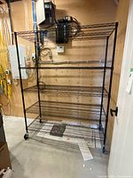 Full view of black 5-shelf wire utility rack on casters