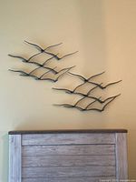 Full view of two seagull sculptures above headboard