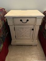 Front view of light wood nightstand showing drawer, cabinet door and overall style