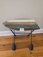 Full view of table front showing paddle-shaped wood top and metal base