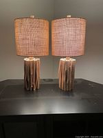 Both wooden stick table lamps lit