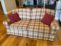 Front view of plaid sleeper sofa with two accent pillows