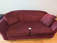 Front view of red pullout couch with cushions