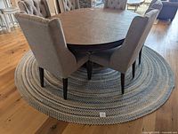 Round braided rug under dining table showing overall size and pattern
