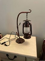 Full view of lantern table lamp on side table showing cord and inline switch