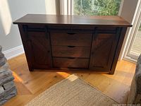Front view of oak TV console showing sliding barn doors and drawers