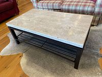 Full view of coffee table showing stone top and metal frame