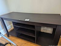 Front view of dark espresso curved-front TV console with open shelves