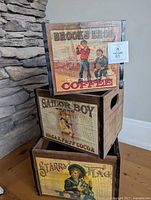 Stacked view of all three decorative wooden crates showing front advertising panels