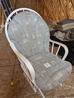Front angled view of white wooden glider rocking chair with cushions