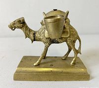 Front view of bronze camel inkwell showing one ink pot and base