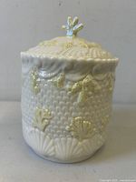 Front view of Belleek shell motif biscuit jar with lid