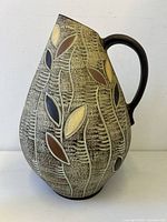 Front of pitcher-form floor vase showing leaf motif and handle