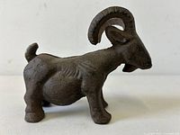 Profile view of cast-iron ram still bank showing overall form and patina.