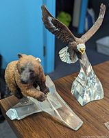 Front view of bear and eagle sculptures on glass bases