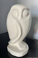 front view of glossy white ceramic owl on pedestal base