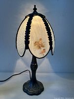 Front view of lit stained glass cherub lamp