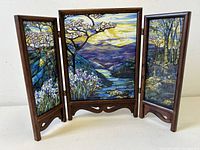 Front view unfolded showing stained glass landscape across three panels