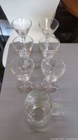 Five stemware glasses and pitcher grouped on table