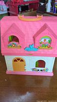 Closed dollhouse exterior showing roof, handle, door, flower decals