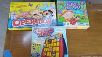Front view of three game boxes: Operation, Hi Ho Cherry-O, Guess Who