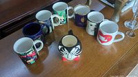 All nine mugs displayed showing variety, fronts visible