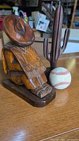 Man figurine, cactus figurine and scale baseball on wooden surface