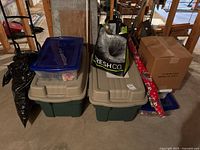 Overall lot showing two large totes, two smaller bins, cardboard box, wrapping paper rolls, shopping bag, black bag
