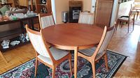 Dining table set showing four of six chairs around round top