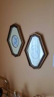 Pair of elongated hexagonal framed prints on wall