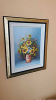 Framed floral oil painting hanging on wall