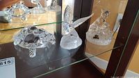 Group shot of the three crystal animal figurines inside display cabinet