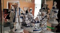 All three porcelain figurines on glass shelf