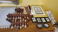 Overall view of spoons on rack and framed items on table
