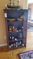 Front view of medium-brown wooden shelf with four fixed shelves