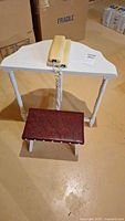 Demi-lune table with telephone on top and footstool below