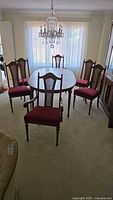 Six matching wood and cane dining chairs around table