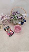 Group shot of vase with flowers, wicker basket with flowers, ceramic bowl, booklet