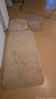 Four beige rugs laid out to show variety in shape and size